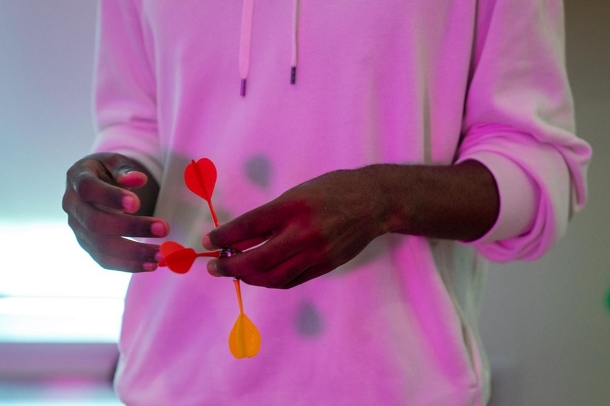 Close-up of hands holding darts symbolising opportunities and choices.